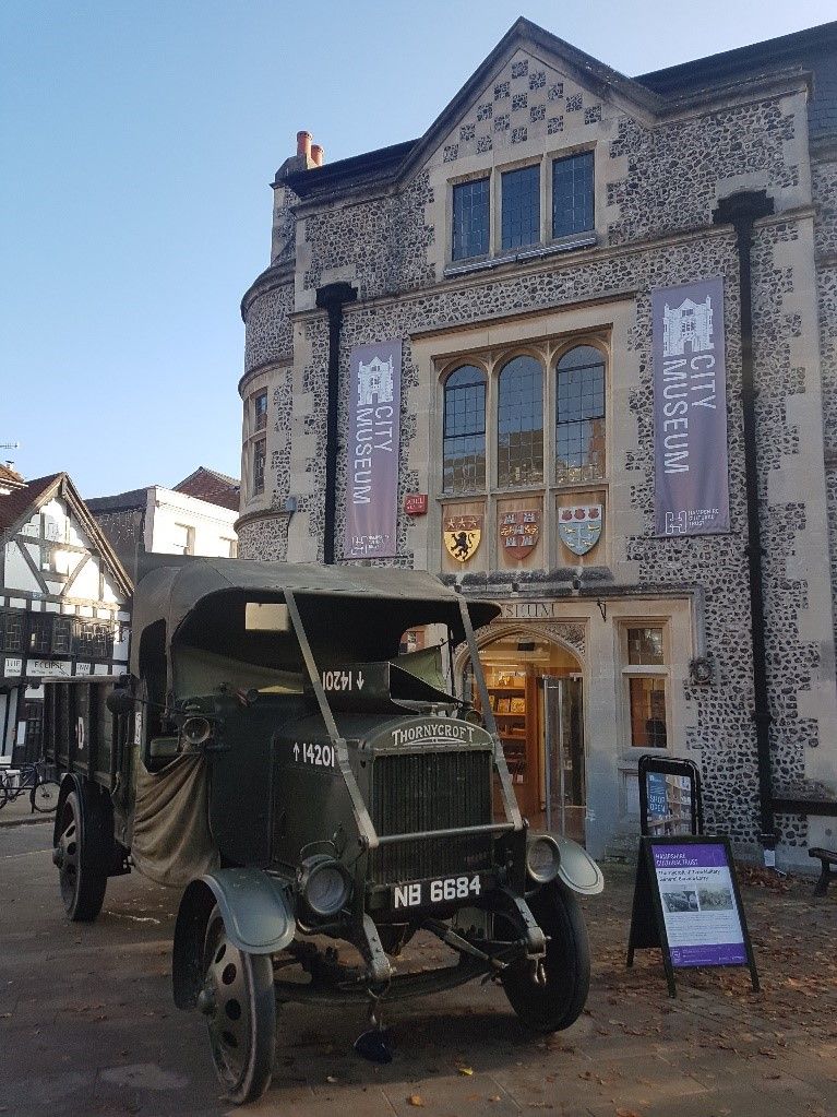 An old truck parked in front of a building

Description automatically generated