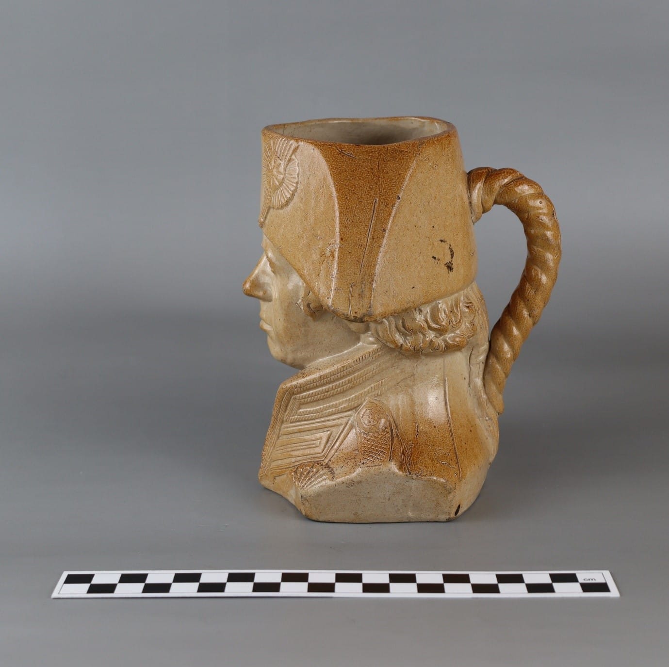 A ceramic mug with a head on it

Description automatically generated